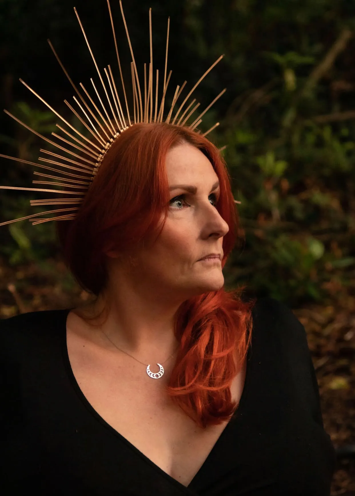 Cate McMurray wearing a golden crown in a woodland setting